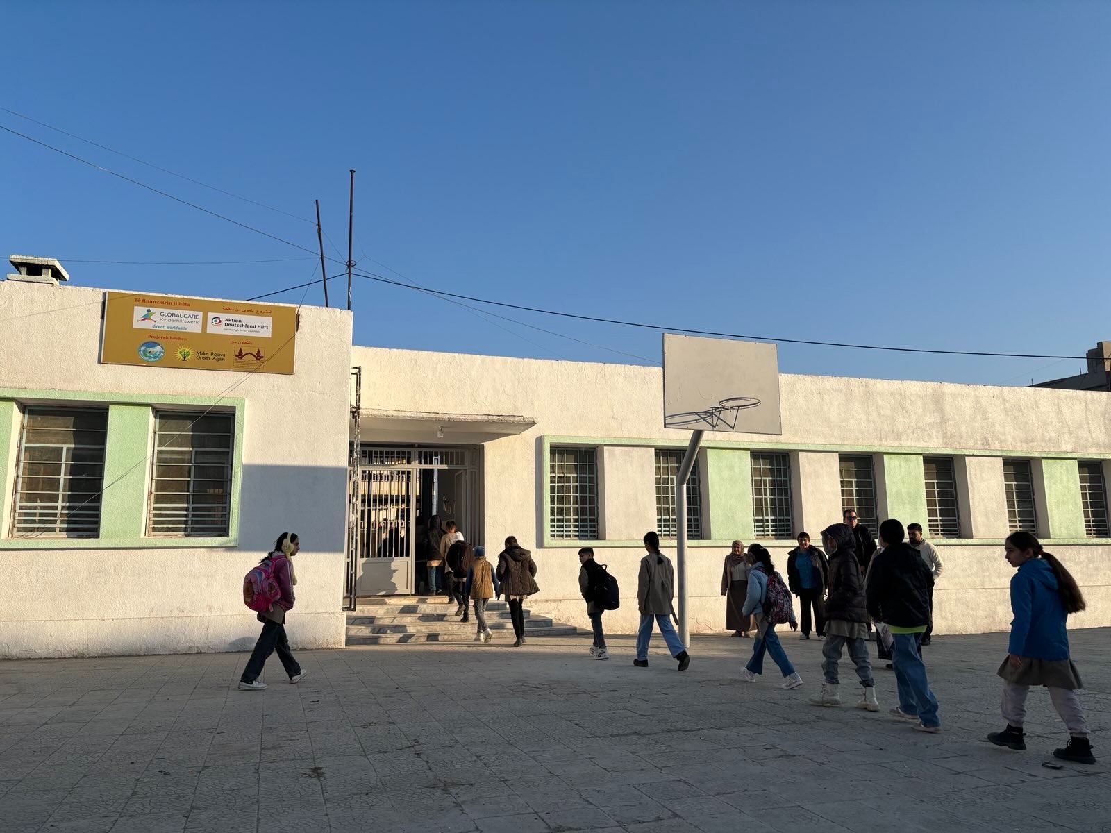 Schülerinnen auf dem Weg in die renovierte Schule